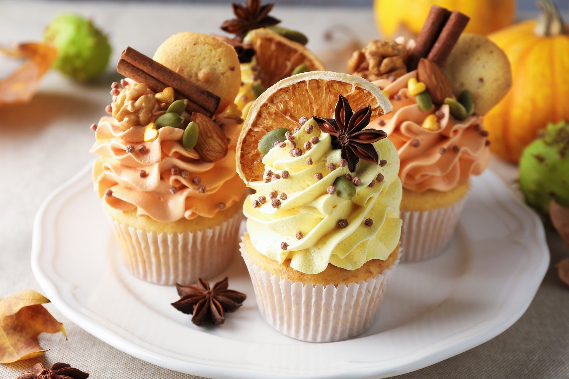 Delicious cupcakes with colorful cream and autumn decor on grey table