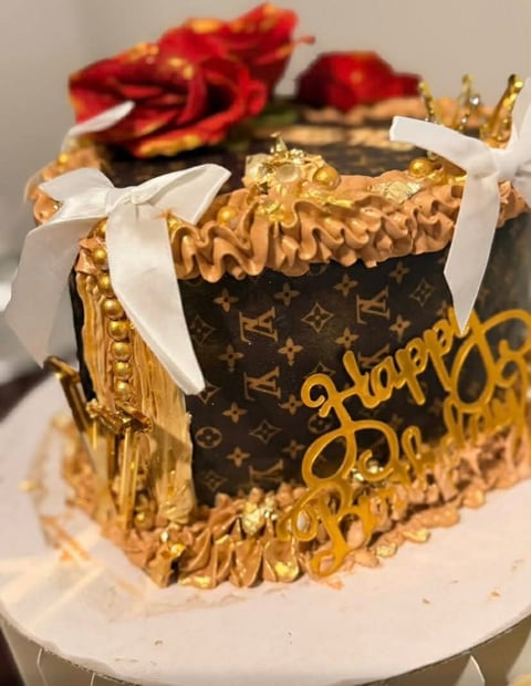 Luxury-themed tiered cake with gold ruffles and Louis Vuitton pattern