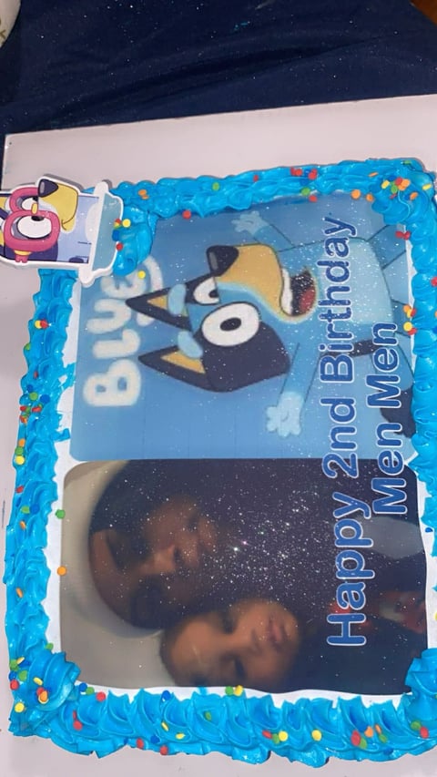 Blue frosted birthday cake with penguin character design and colorful sprinkles for a 2nd birthday celebration