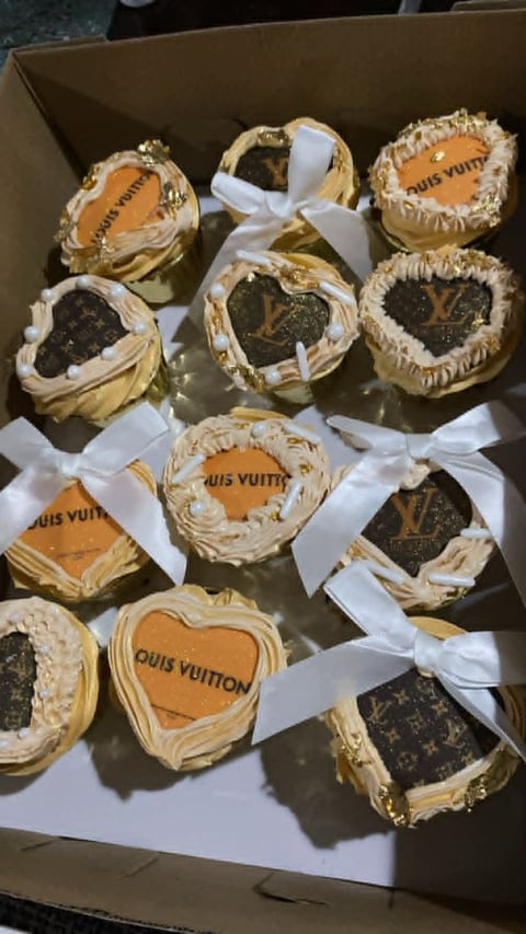 Box of luxury-themed decorative cupcakes with Louis Vuitton monogram details